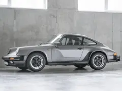 Grauer Porsche 911 G-Modell steht vor einer Betonwand.