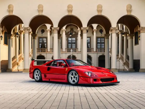 Ein roter Ferrari F40 steht vor einer prächtigen Villa mit Säulengängen.