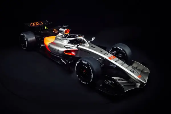 Ein silberner und oranger Audi F1 Auto mit dem Audi-Logo auf dem Heckflügel.