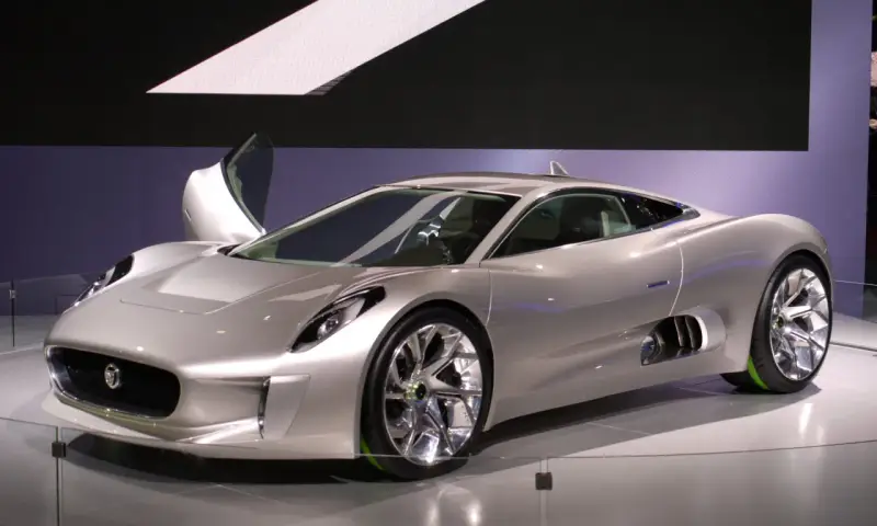 Silberner Jaguar C-X75 mit Flügeltür, der auf einer Messe ausgestellt wird.
