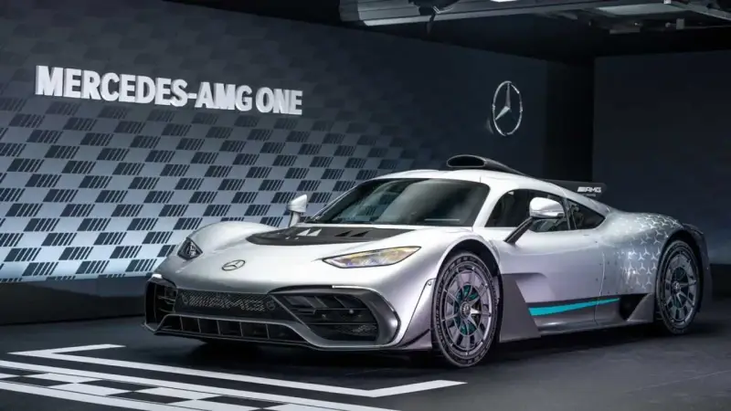 Silberner Mercedes-AMG ONE mit auffälligem Design und dem Schriftzug "MERCEDES-AMG ONE" im Hintergrund.